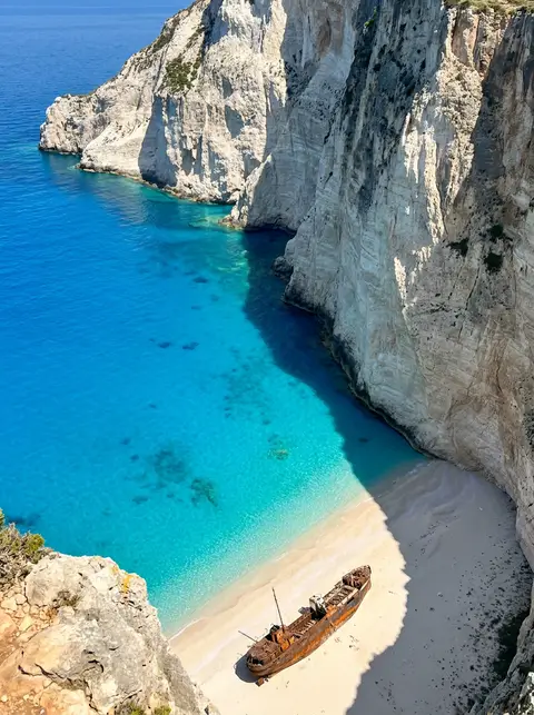 Navagio cove on Zakynthos with white cliffs and layered turquoise water