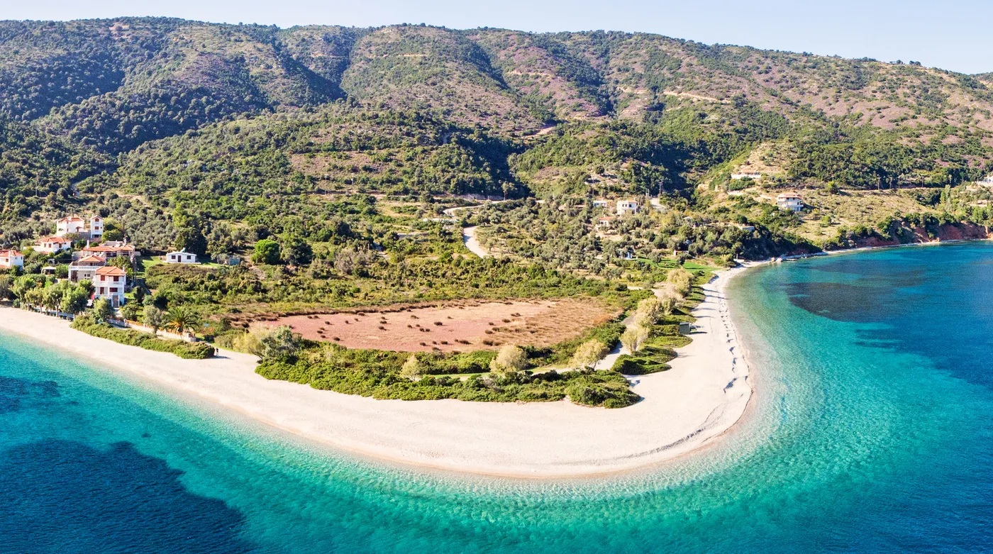 The long curve of Agios Dimitrios beach on Alonnisos, white shingle against turquoise water