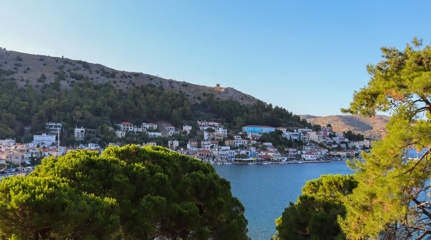 Chios Town and its harbour seen through the pines on the slope above