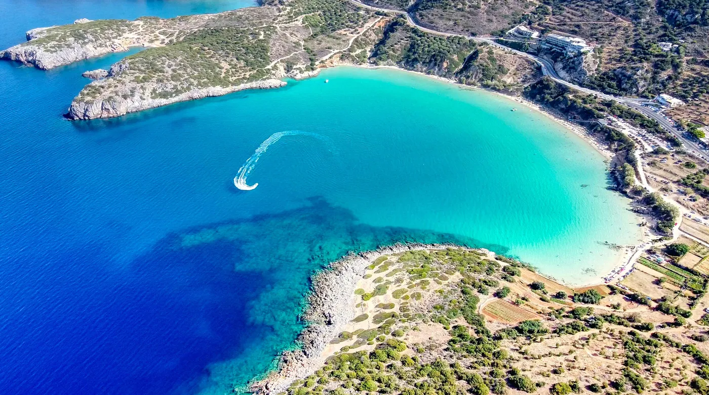 The horseshoe of Voulisma beach near Agios Nikolaos on Crete, shallows shading from turquoise to deep blue