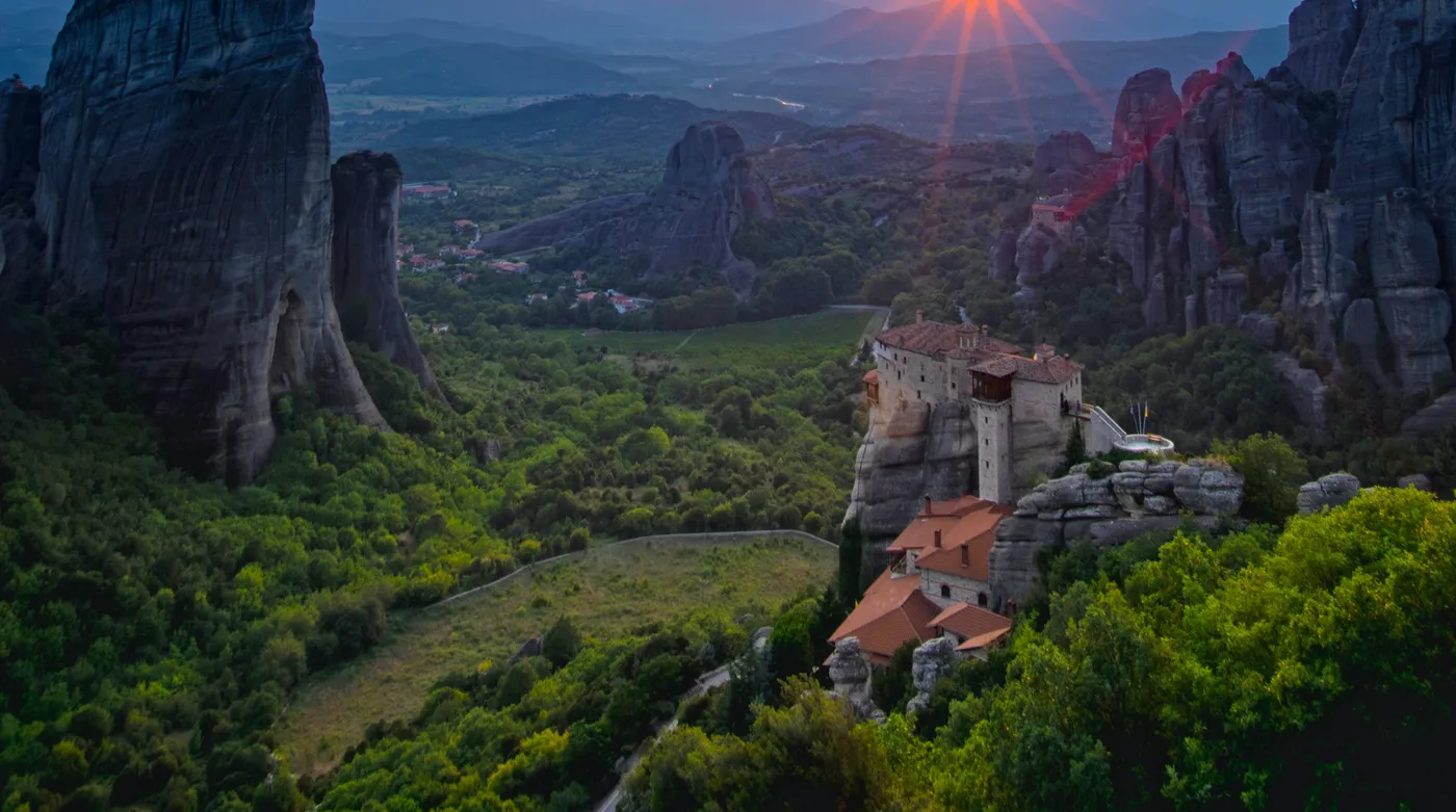 The sun setting between rock pillars on the Greek mainland