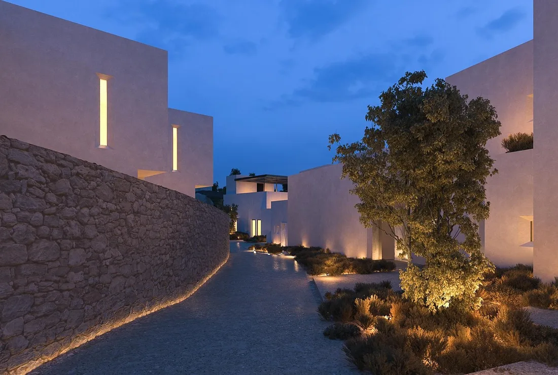 Whitewashed suites along a lit stone lane at dusk